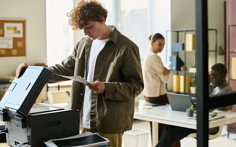 small office with man standing at a small printer