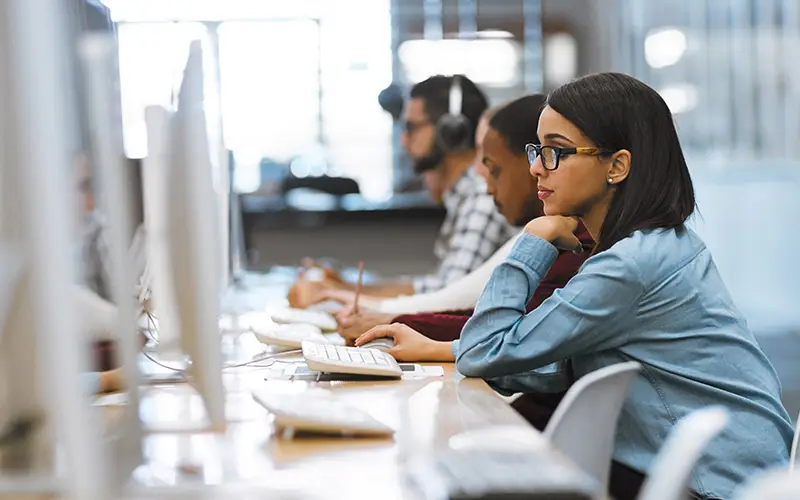 University computer lab with three people sitting at computers